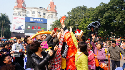 節目《財神到》掀起全場高潮，市民群眾把派利是的“財神爺”包圍。